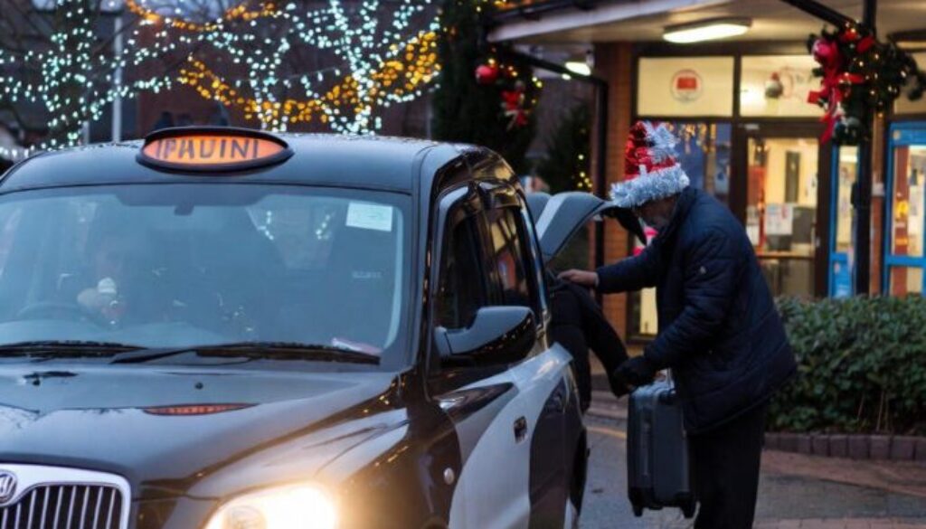 A clean Waltham Cross Taxis vehicle parked on a festive street in Waltham Cross during Christmas, with lights in the background.