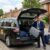 Professional Waltham Cross Taxis driver loading passenger luggage into a clean, modern minicab for an airport transfer.